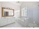 Bright primary bathroom featuring dual vanities, a soaking tub, and a walk-in shower with glass doors at 795 Lake Medlock Dr, Alpharetta, GA 30022