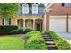 Brick home featuring a covered porch, stone steps, and well-maintained landscaping leading to the front door at 795 Lake Medlock Dr, Alpharetta, GA 30022