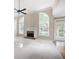 Bright living room featuring a brick fireplace, ceiling fan, neutral walls, and large arched windows at 795 Lake Medlock Dr, Alpharetta, GA 30022