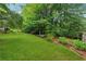 View of the home's private backyard featuring green grass, mature trees, and lush gardens at 2900 Townley Cir, Atlanta, GA 30340