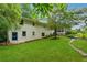View of the home's backyard featuring green grass, mature trees, and access to a screened in back porch at 2900 Townley Cir, Atlanta, GA 30340