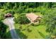 Aerial view of a single-story home, carport, and a long driveway surrounded by lush greenery at 3956 Tell Sw Rd, Atlanta, GA 30331
