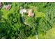 Aerial view of a one-story house surrounded by dense trees, with a long driveway and small outbuilding at 3956 Tell Sw Rd, Atlanta, GA 30331