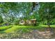 Exterior view of a yellow home with a beautiful front yard and mature trees offering shade at 3956 Tell Sw Rd, Atlanta, GA 30331