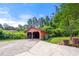 Detached two-car garage with a large driveway and mature trees at 3956 Tell Sw Rd, Atlanta, GA 30331
