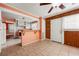 Eat-in kitchen featuring a breakfast bar, tile floors, wood paneling, and white ceiling and trim at 3956 Tell Sw Rd, Atlanta, GA 30331