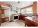 Eat-in kitchen featuring tile countertops, tiled backsplash, white cabinets, and white appliances at 3956 Tell Sw Rd, Atlanta, GA 30331