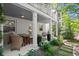 Charming back porch with comfortable seating, an outdoor table, and views of the surrounding trees at 420 Banbury Xing, Alpharetta, GA 30009