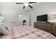 Bright bedroom with a comfy bed, a dresser with a television, and a view into the room with the piano at 420 Banbury Xing, Alpharetta, GA 30009