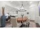 Bright dining room boasts modern chandelier, coffered ceiling, and open access to the kitchen at 420 Banbury Xing, Alpharetta, GA 30009