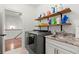 Laundry room with washer, dryer, and storage shelves provides functional convenience and organization at 420 Banbury Xing, Alpharetta, GA 30009