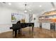 Living room with a piano, wet bar, brick accents, and polished concrete floors at 420 Banbury Xing, Alpharetta, GA 30009