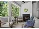 Inviting outdoor porch with fireplace, ceiling fan, cushioned seating, and forest backdrop at 420 Banbury Xing, Alpharetta, GA 30009