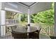 Cozy porch with round table, wicker chairs, and retractable screens offering beautiful outdoor views at 420 Banbury Xing, Alpharetta, GA 30009