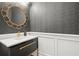 Modern powder room featuring gray wallpaper, gold hardware, and stylish round mirror at 420 Banbury Xing, Alpharetta, GA 30009