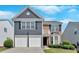 Charming two-story home featuring a combination of brick and blue siding, plus a two-car garage and manicured landscaping at 535 Watercress Dr, Woodstock, GA 30188
