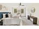 Bright bedroom features neutral decor, carpeted floor, fan, two windows, and furniture at 5759 Albans Way, Lithonia, GA 30058