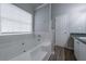 Relaxing bathroom featuring soaking tub, tiled wall and wood look floors at 5779 Wellborn Creek Dr, Lithonia, GA 30058