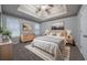 Spacious main bedroom with large bed, modern decor, and a tray ceiling at 5779 Wellborn Creek Dr, Lithonia, GA 30058