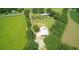 Aerial view of a sprawling country estate featuring several buildings, lush green fields, and mature trees at , Social Circle, GA 30025