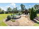 This backyard features a stock tank pool, landscaping, and a wooden deck with chairs on a sunny day at , Social Circle, GA 30025