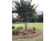 Spacious backyard featuring a mature tree, landscaped flower bed, and fenced perimeter at , Social Circle, GA 30025