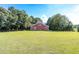 Spacious red barn on a verdant lawn surrounded by mature trees and a fence at , Social Circle, GA 30025