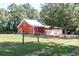 Red barn exterior with white trim and metal roof, surrounded by a green lawn at , Social Circle, GA 30025