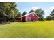 Large, red barn exterior with white trim, situated on a lush green lawn at , Social Circle, GA 30025