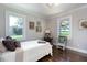 This bedroom features hardwood floors, neutral walls, white trim, and bright windows overlooking the property at , Social Circle, GA 30025