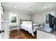 Bright bedroom featuring hardwood floors, a black metal bed frame, and cool-toned walls with white trim at , Social Circle, GA 30025