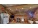 Rustic bonus room featuring wood-paneled walls, metal ceiling, a refrigerator, and comfortable seating at , Social Circle, GA 30025