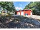 Exterior view of a bright red barn with multiple garage doors, surrounded by trees at , Social Circle, GA 30025