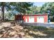 Exterior of red barn featuring three garage doors, retaining wall, and lawn at , Social Circle, GA 30025