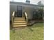 Charming front porch with wooden stairs, black railings, and green lawn at , Social Circle, GA 30025