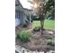 Landscaped front yard with mature trees, garden beds, and charming stone accents at , Social Circle, GA 30025