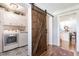 Hallway features stylish barn door leading to a combined laundry and bathroom, and open access to living spaces at , Social Circle, GA 30025