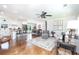 Open-concept living room featuring hardwood floors, a ceiling fan, and access to the dining area and modern kitchen at , Social Circle, GA 30025