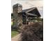 Outdoor stone fireplace and covered patio area with hanging plants and lush greenery at , Social Circle, GA 30025