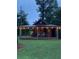 Quaint outdoor structure with a covered porch, rocking chairs, and ambient string lights at , Social Circle, GA 30025
