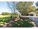 Lush property featuring large green lawn, mature trees, gravel driveway, and covered parking at , Social Circle, GA 30025