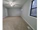 Large bedroom with neutral carpet, ceiling fan, two windows, and a white door at 1194 Clichy Ct, Marietta, GA 30066