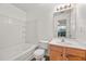 Bright bathroom with white tiled shower/tub, wood vanity, and large mirror, offering ample space at 2736 Parkway Trl, Lithonia, GA 30058