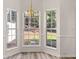 Bright breakfast nook featuring large windows with backyard view and wood-look floors at 2736 Parkway Trl, Lithonia, GA 30058