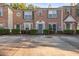 Brick townhome featuring well-maintained landscaping, classic shutters, and assigned parking at 2736 Parkway Trl, Lithonia, GA 30058
