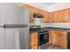 Updated kitchen with stainless steel refrigerator and appliances, wood cabinets, and black countertops at 2736 Parkway Trl, Lithonia, GA 30058
