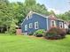 Side exterior view of blue house with well-manicured lawn and wood privacy fence at 3226 Hope St, Hapeville, GA 30354