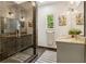 Modern bathroom featuring a glass shower, dual vanities, granite counters and stylish neutral color palette at 588 Angier Ne Ave, Atlanta, GA 30308
