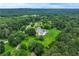 An expansive estate home is pictured in this aerial view that shows a swimming pool and sprawling wooded acreage at 2595 Ross Rd, Snellville, GA 30039