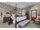 Bedroom with a four poster bed, floral wallpaper, and dark wood furniture at 2595 Ross Rd, Snellville, GA 30039